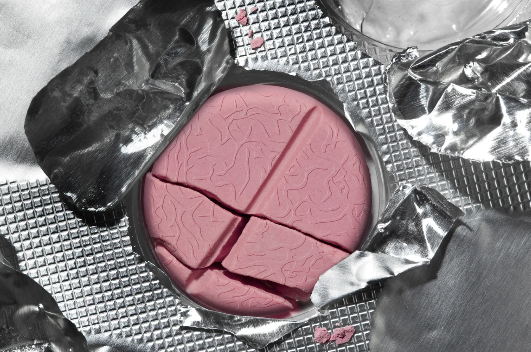 A pink pill resembling a brain cracks